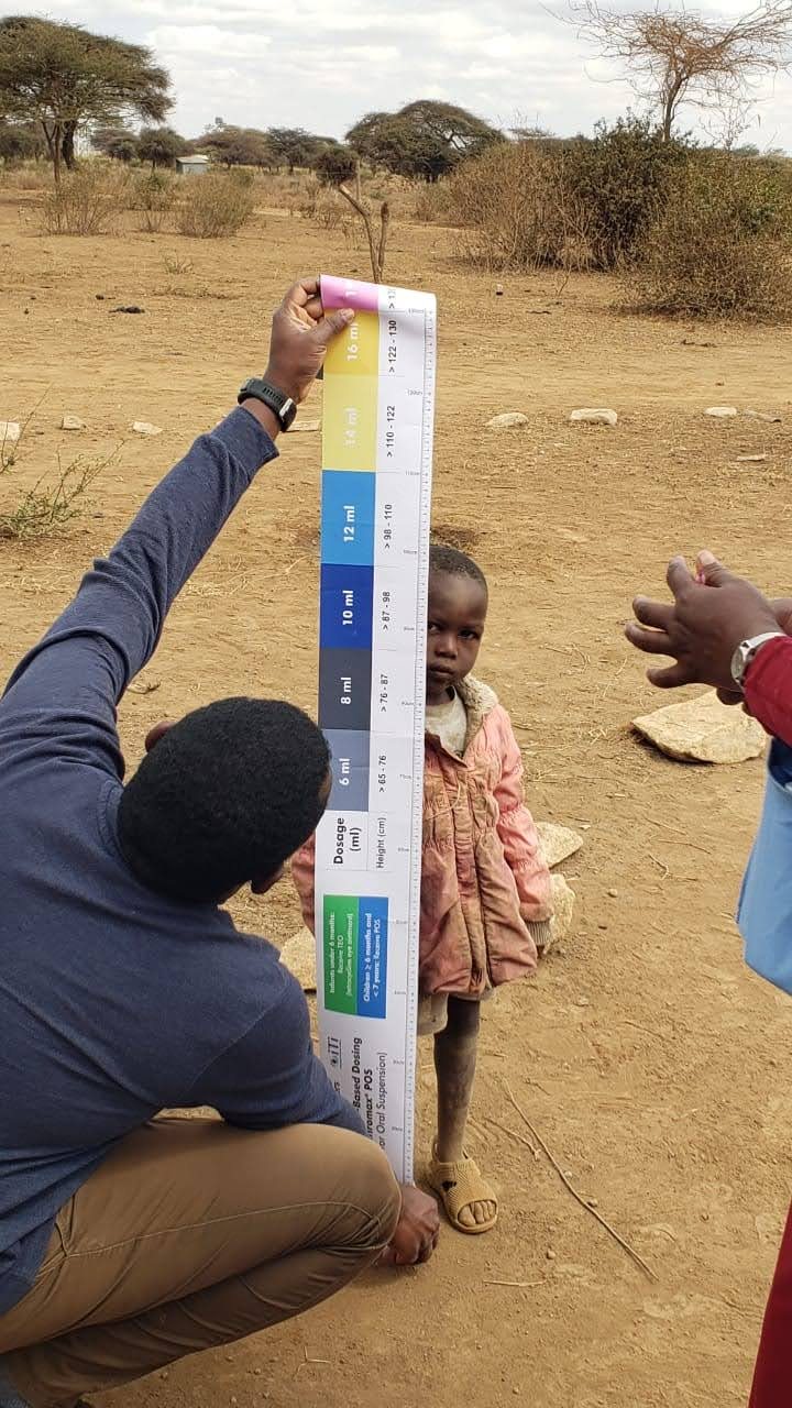 A volunteer measuring a child's height during a nutrition screening